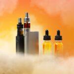 Elfliq Mini Liquids und E-Zigaretten vor orangefarbenem Hintergrund mit Dampf