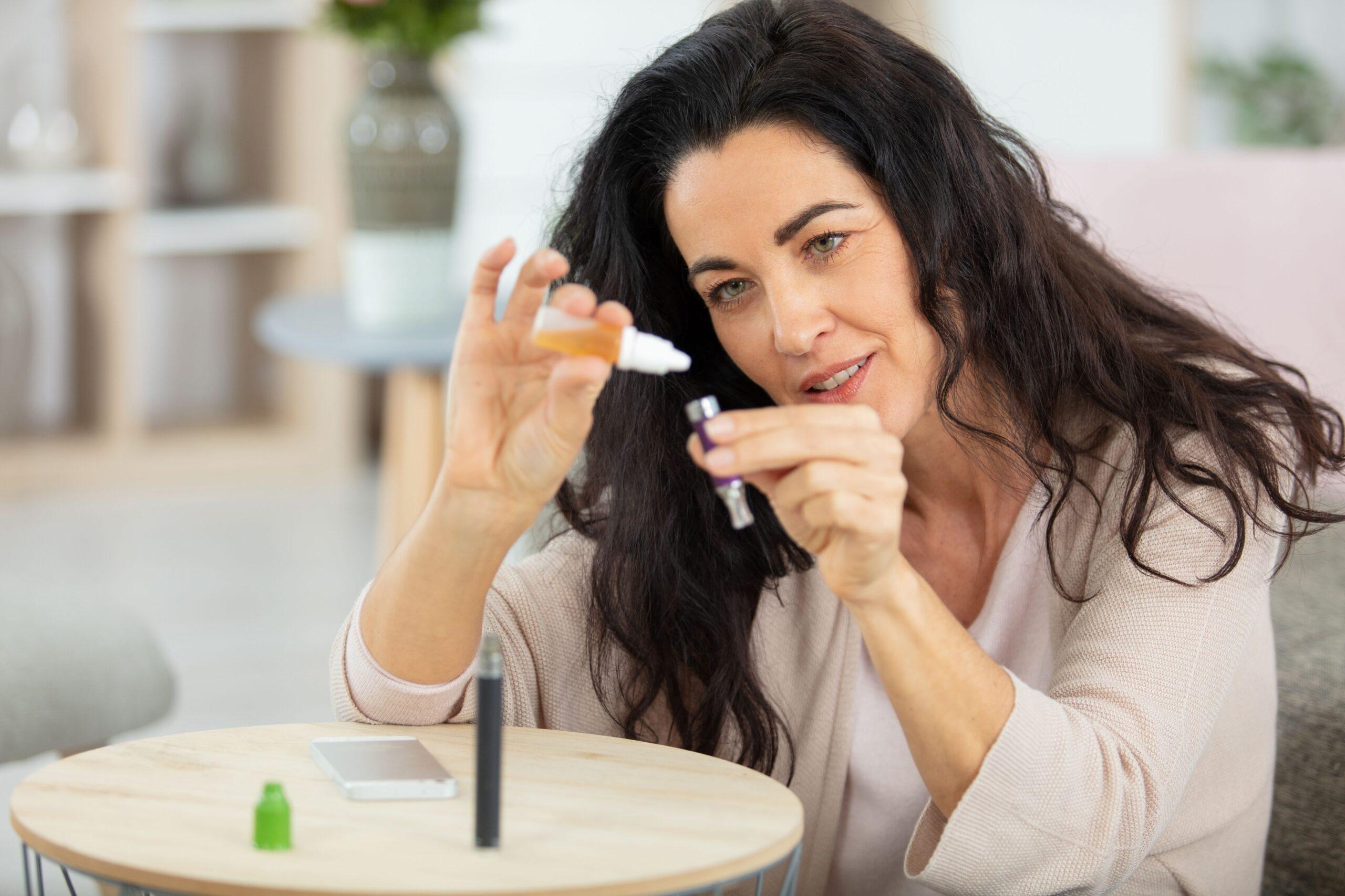 Frau füllt kleine E-Zigaretten Kartusche mit Elfliq Mini Liquid