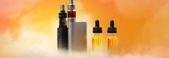 Elfliq Mini Liquids und E-Zigaretten vor orangefarbenem Hintergrund mit Dampf